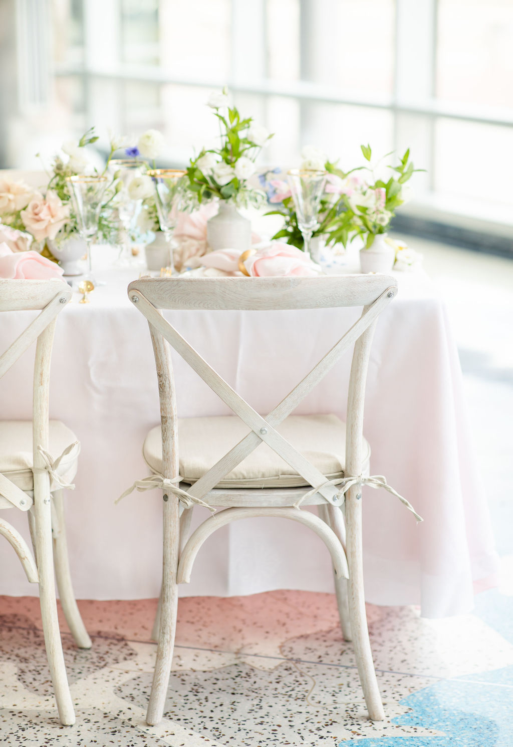 A chair and table setting in light pink and lime green florals for wedding venue in Denver.