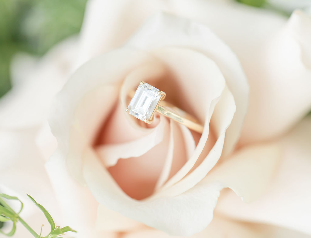 Engagement ring sitting inside pink rose at Denver wedding venue.