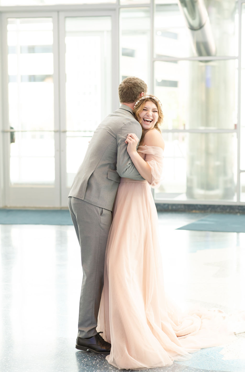 Bride laughing as she dances with groom at Denver wedding venue.