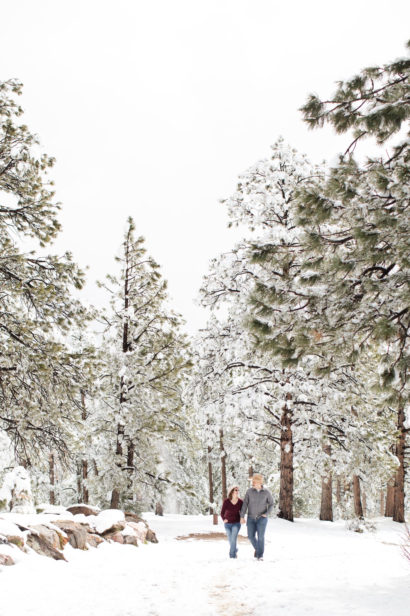Couple walks through snowy woods in Colorado.