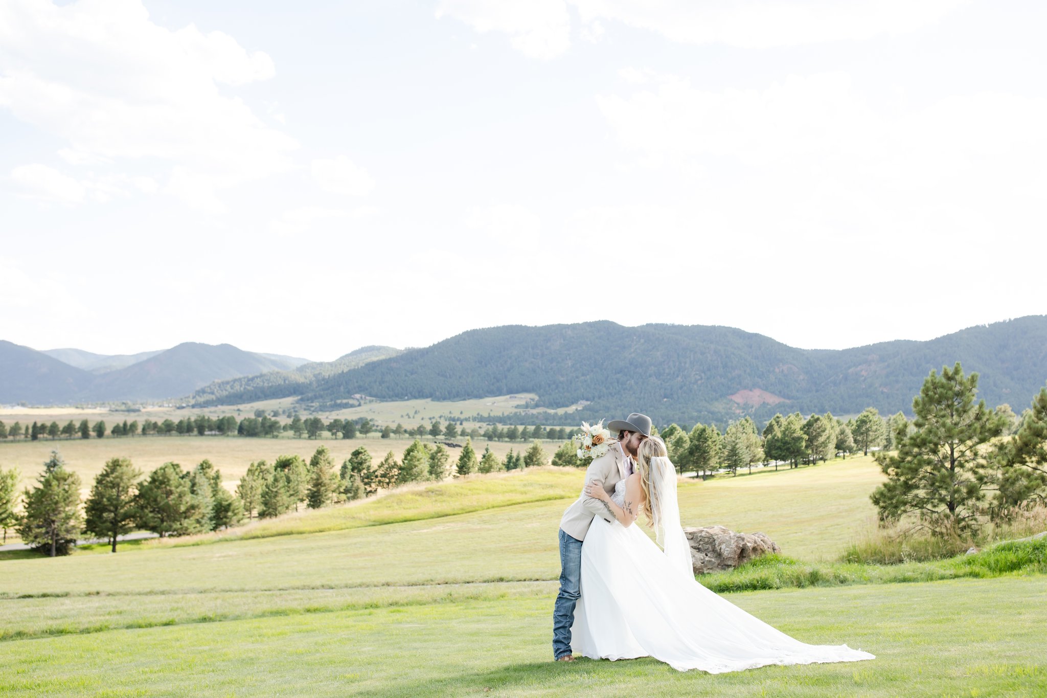 Bride and groom share a kiss at Spruce Mountain Events in Colorado.