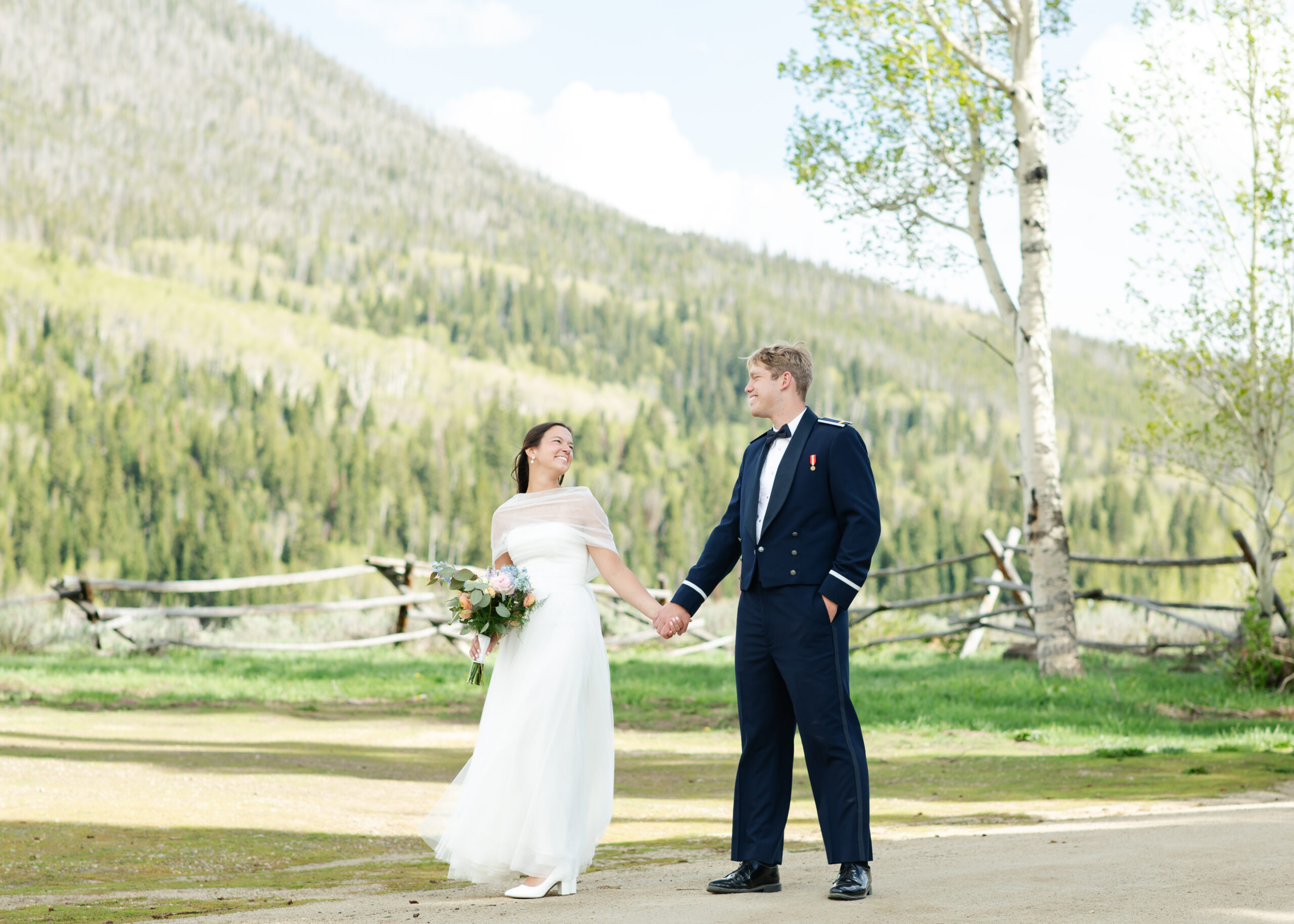 Bride smiling at groom near mountains in Granby, Colorado.