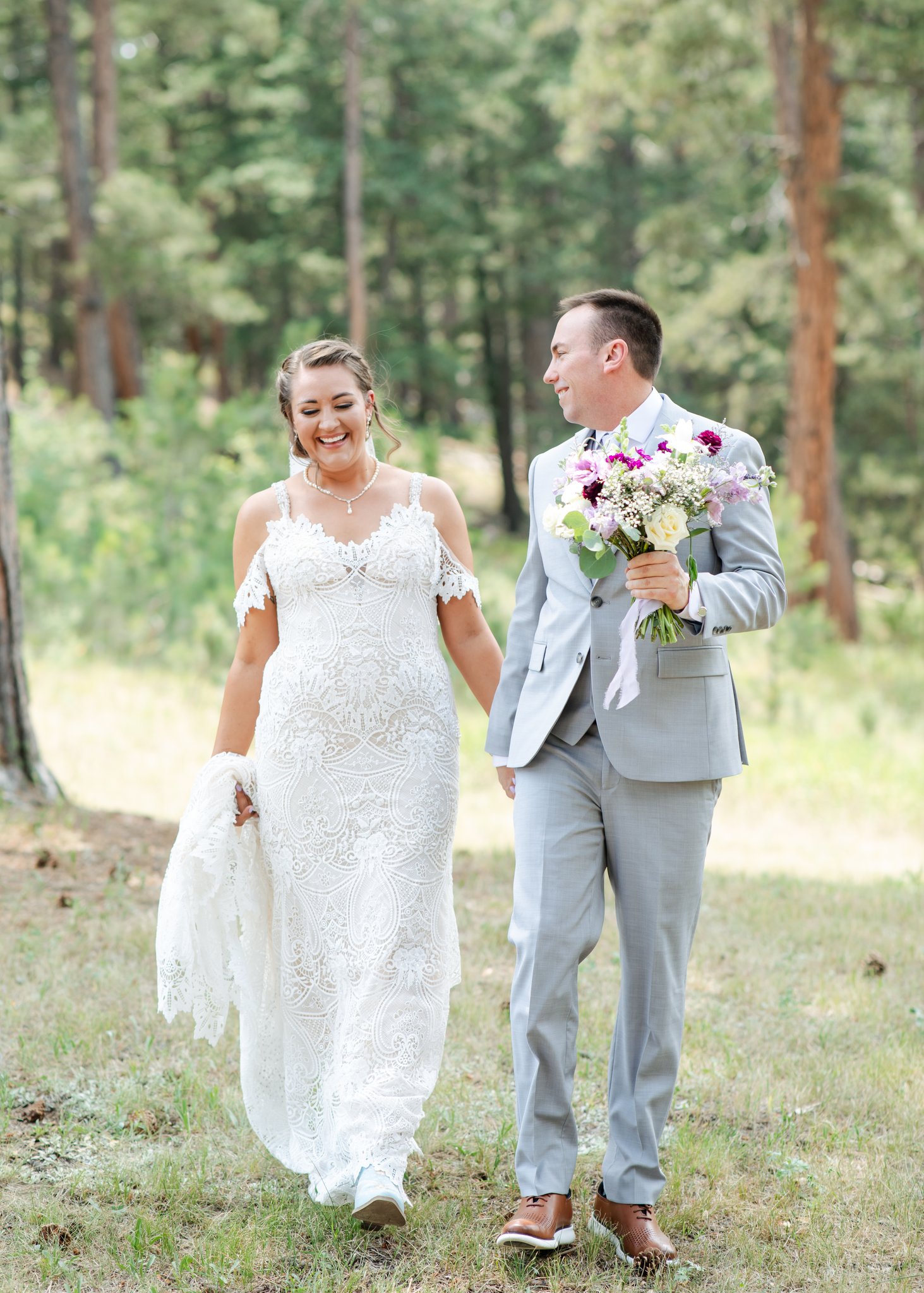 Bride and groom walking through woods at Younger Ranch wedding venue as example of not an AI wedding photo.