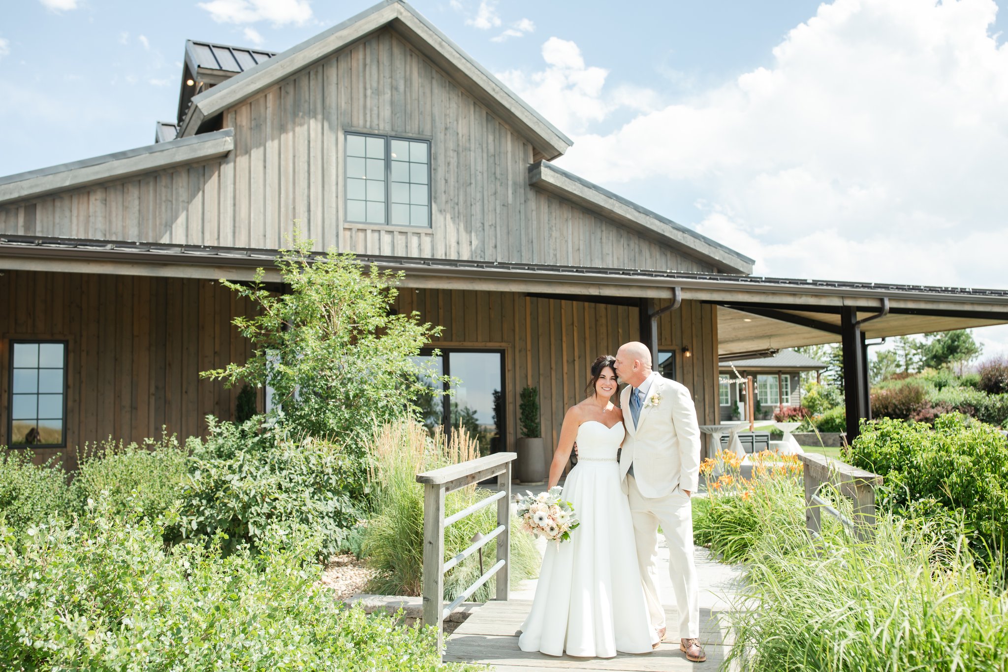 Bride and groom stand in a garden at a winery wedding venue in Colorado.