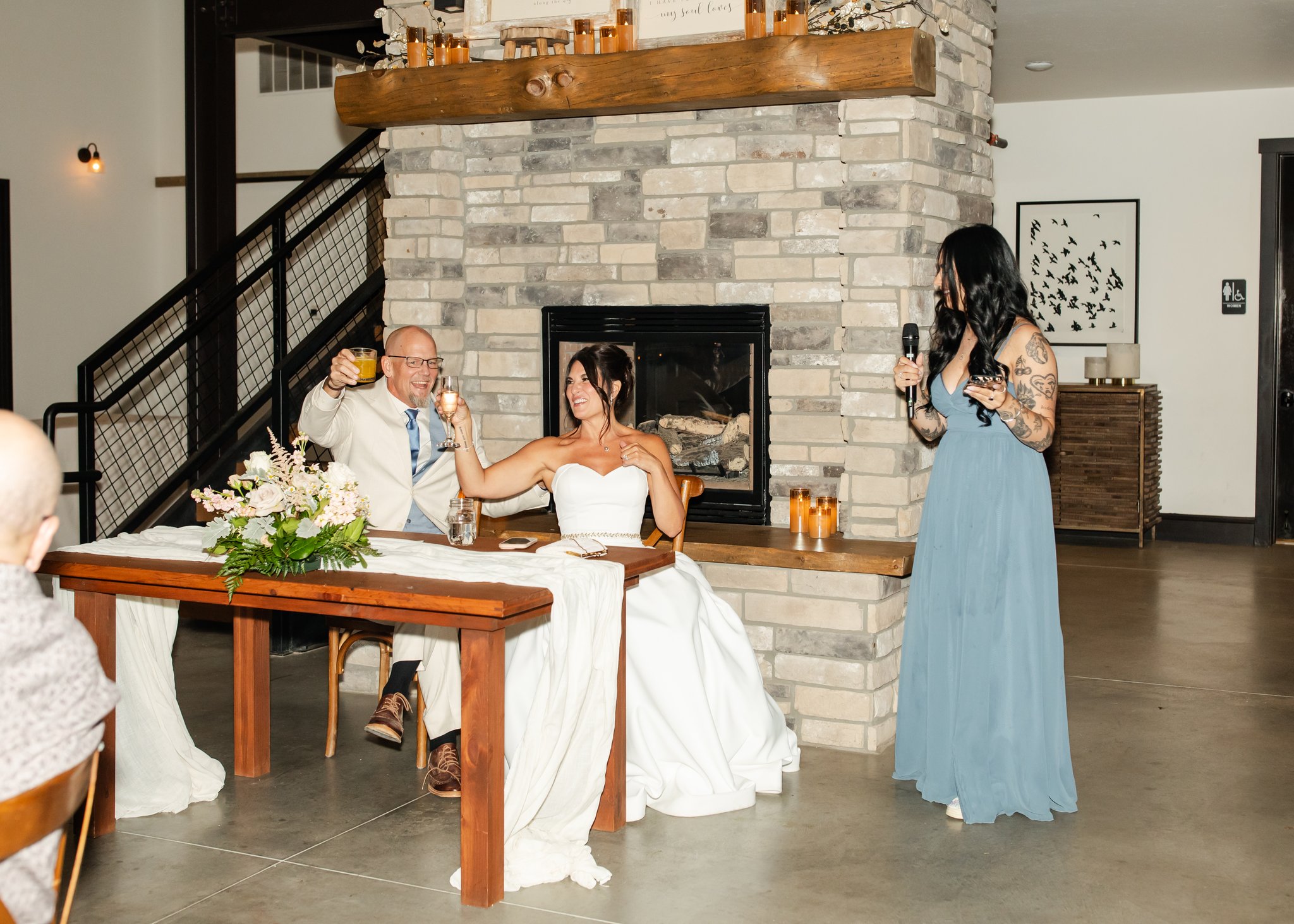 Bride and groom cheers their drinks as an example of a reception at a Colorado winery wedding venue.
