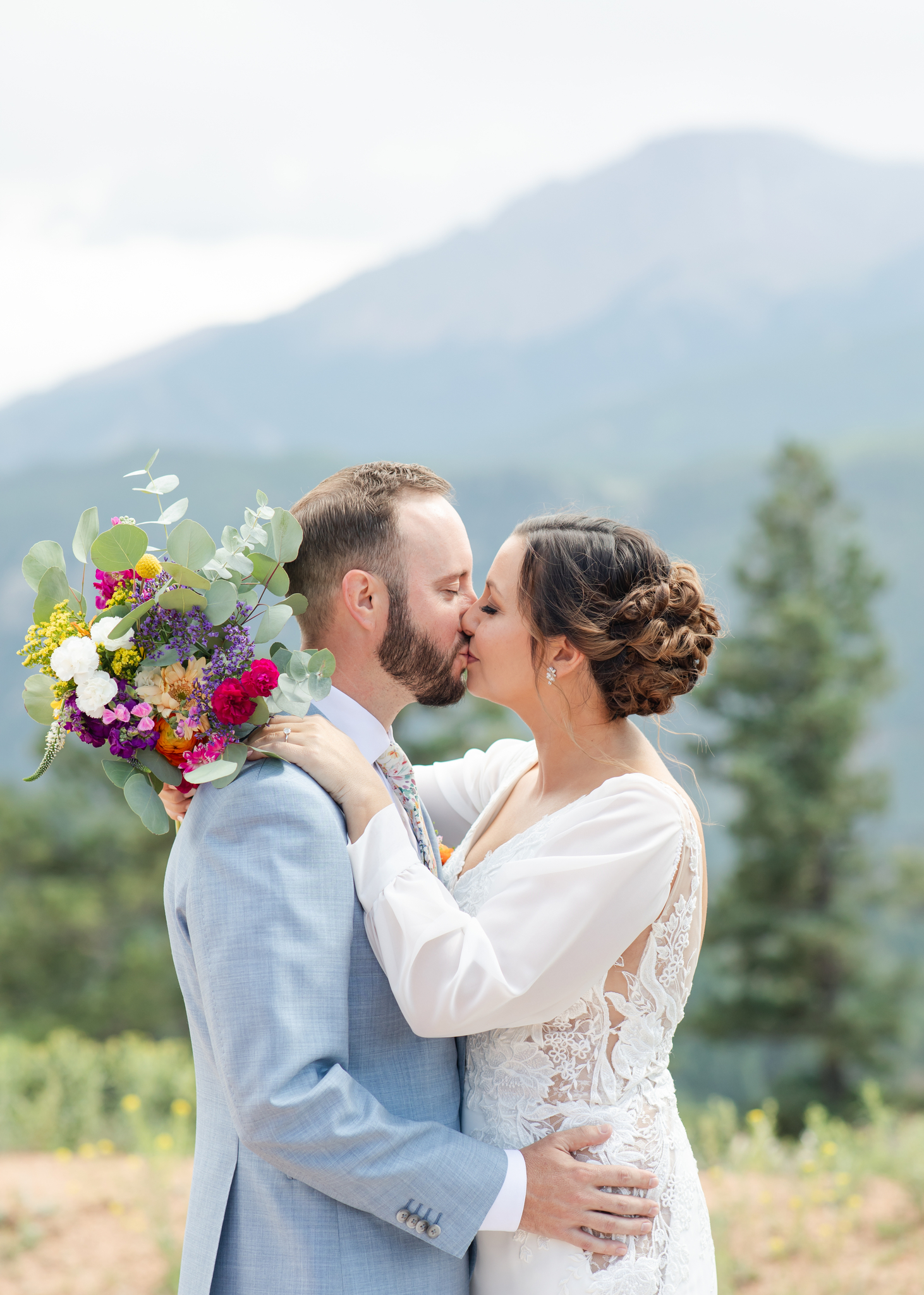 Bride and groom kissing at their Colorado wedding near the mountains of Woodland Park.