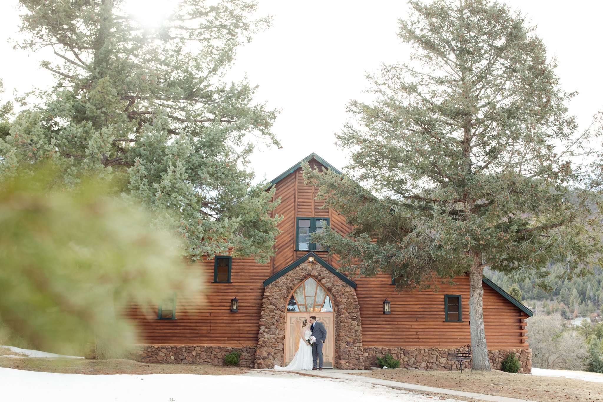 Bride and groom standing in front of chapel at Pinecrest Wedding venue in Colorado Springs, CO.