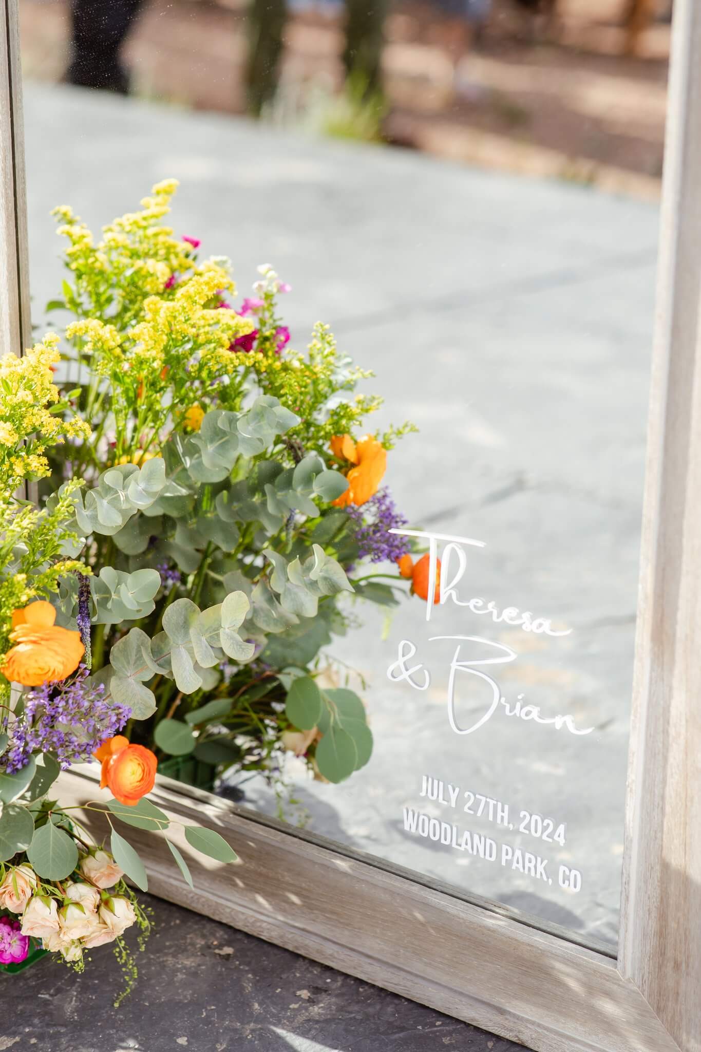 Details of a custom design on a mirror for a wedding with colorful florals
