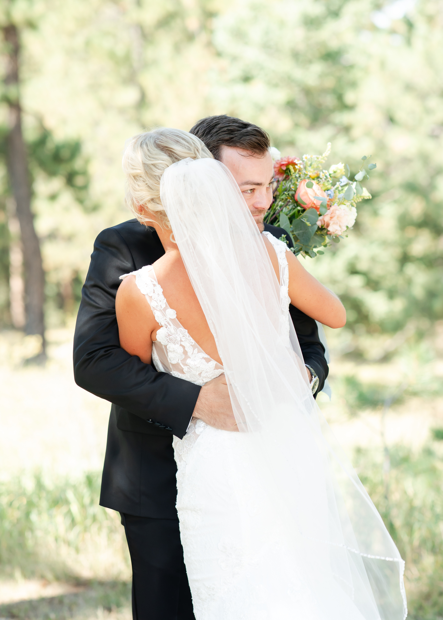 Happy newlyweds embrace for a hug in the forest